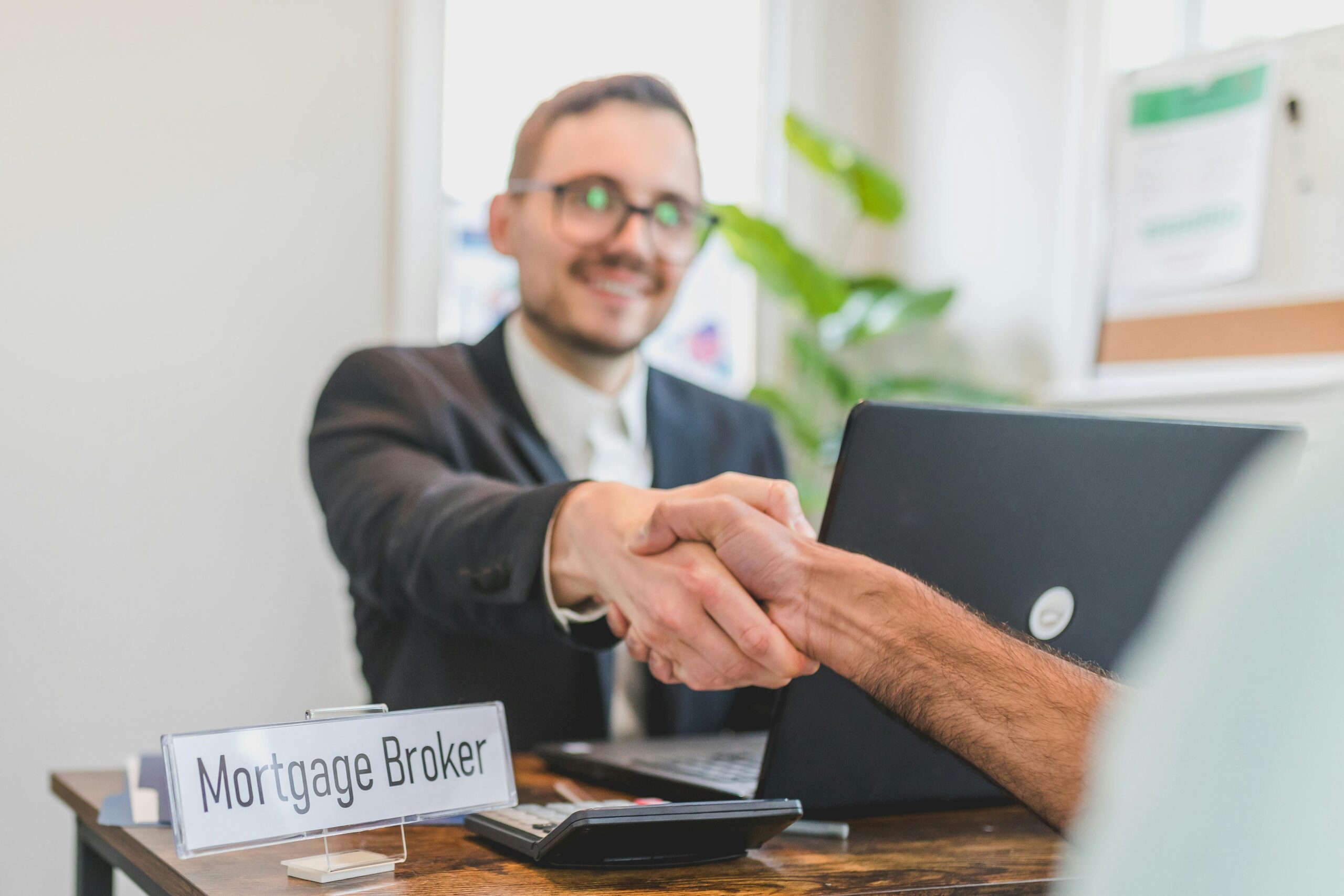 A Broker Shaking Having a Deal with the Person Sitting in front of Him